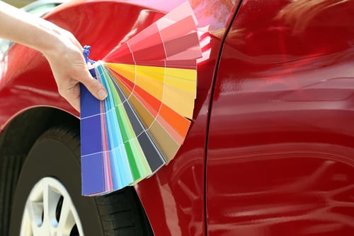 hand-with-paint-samples-choosing-color-for-painting-car